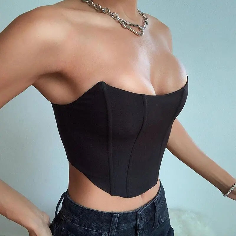 Person wearing a black strapless top with a blurred background