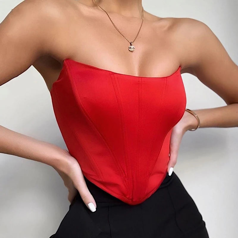 Person wearing a red strapless top against a neutral background