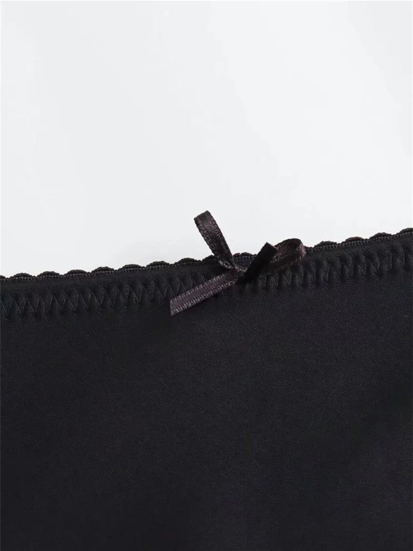 Close-up of a black bra with lace trim on a white background