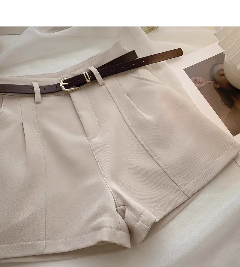 Beige shorts with a brown belt on a light background