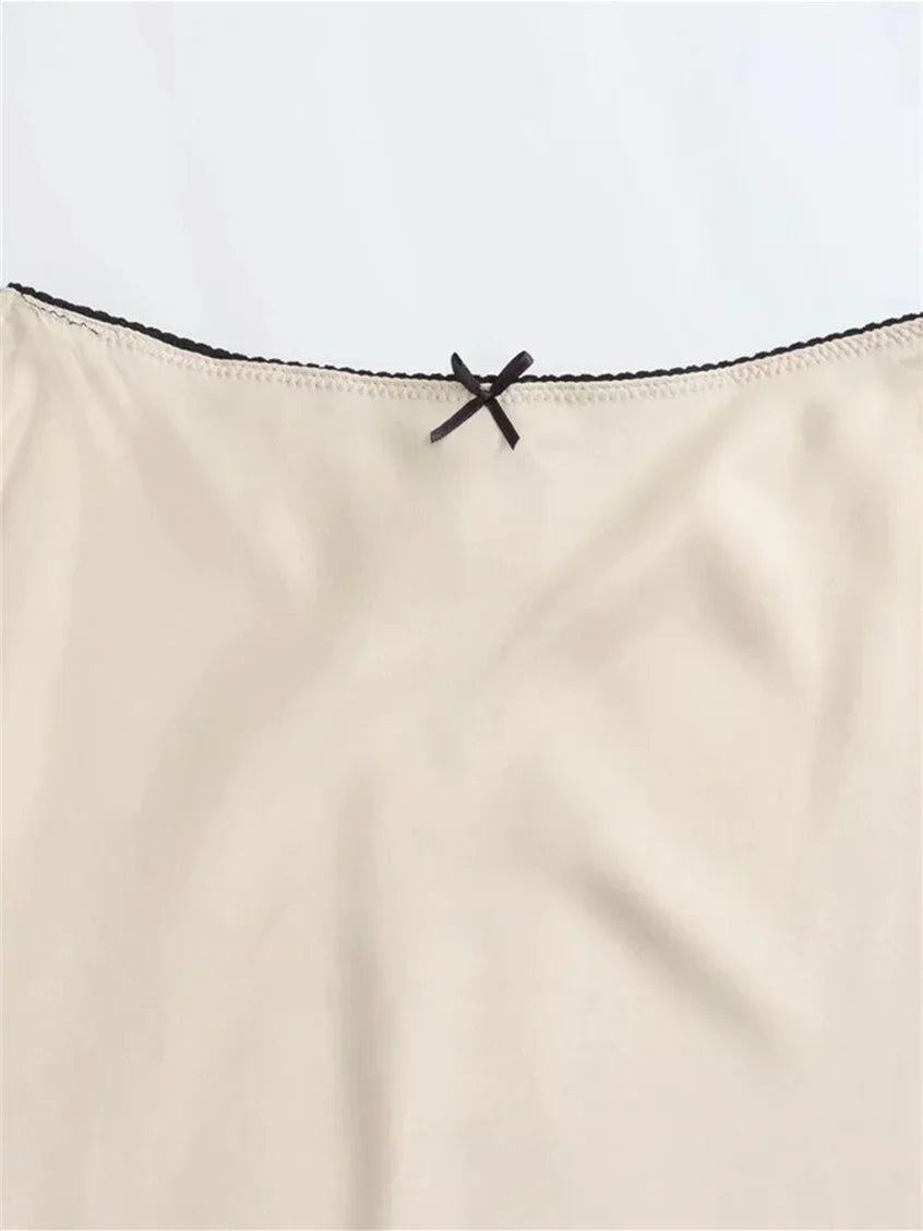 Beige strapless top with black lace trim on a light gray background