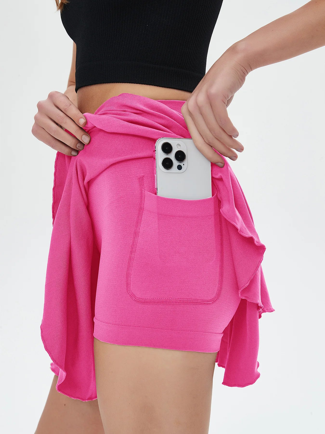 Person wearing a pink outfit with a phone in a pocket against a white background - RemarkStore