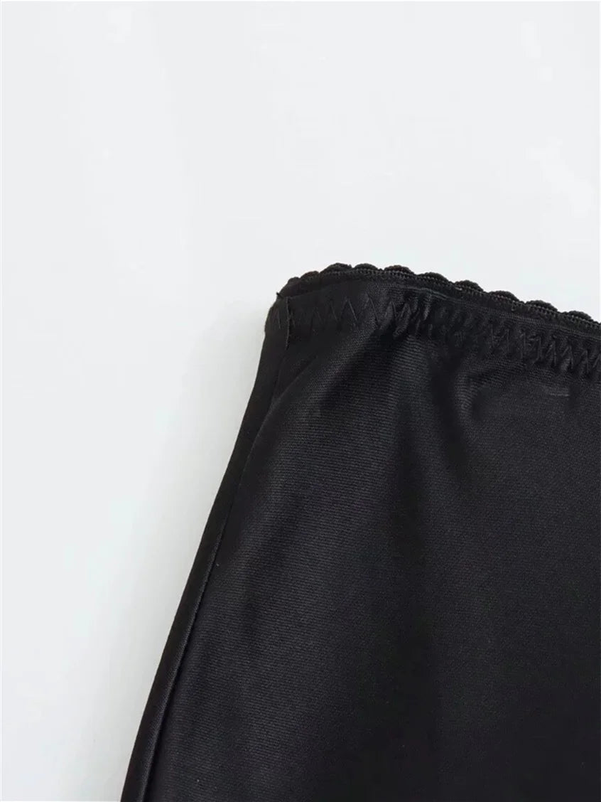 Black pants with a scalloped hem on a white background
