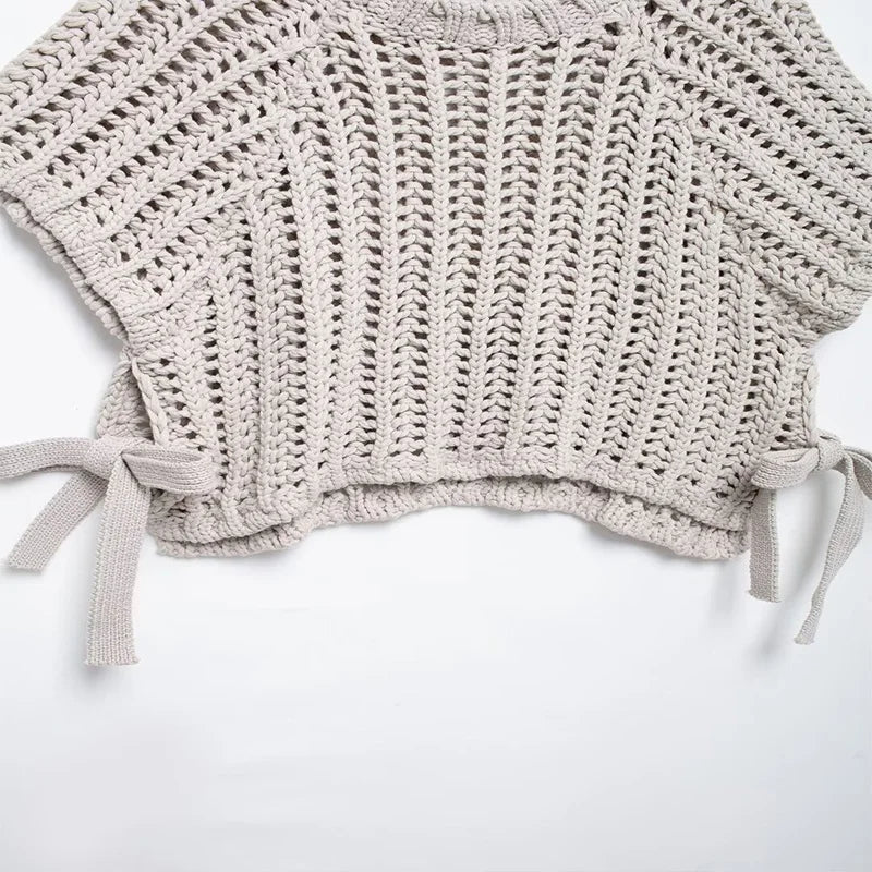 Crocheted beige top with tied sleeves on a white background