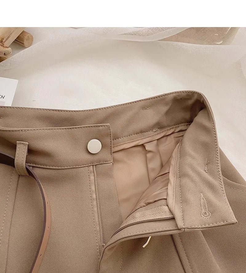 Close-up of a beige jacket with a button and collar detail on a light background